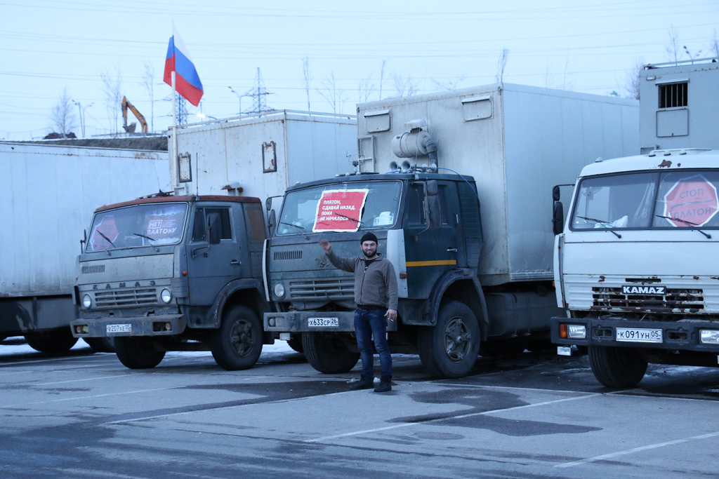 Striking Dagestani trucker  in front of his rig. The placard on the windshield reads, "Plato, put it into reverse before it kicks off." Photo by and courtesy of anatrrra